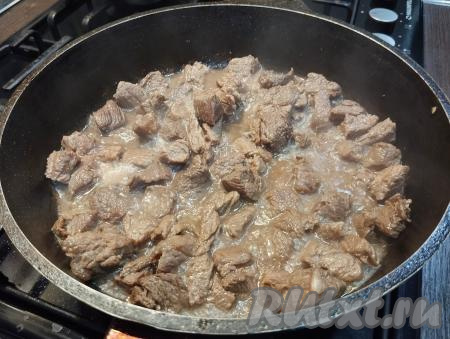 Затем добавляем соль, специи, вливаем 250 миллилитров воды, даём воде закипеть, уменьшаем огонь. Тушим говядину под крышкой 12-15 минут (до мягкости мяса), периодически перемешивая.