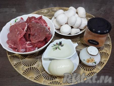 Подготовим ингредиенты для приготовления говядины с шампиньонами на сковороде. Лук очищаем. Говядину, если она заморожена, размораживаем. Моем мясо, обсушиваем. Шампиньоны промываем водой, с грибов снимаем верхнюю плёнку, обсушиваем.