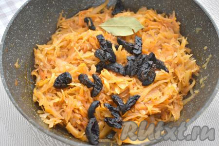 Подготовленный чернослив нарезаем на 2-3 части. После того как тушёная капуста станет достаточно мягкой, добавляем к ней лавровый лист и нарезанный чернослив, перемешиваем, готовим 5 минут, иногда перемешивая. Убираем готовое блюдо с огня.