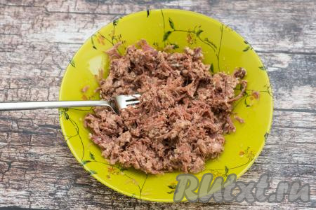 Тушёнку в тарелке размять вилкой.