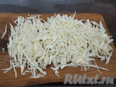 Капусту нарезаем на тонкие полоски. Немного мнём капусту руками, чтобы она выделила немного сока, стала более мягкой и сочной. Если используете молодую капусту, тогда её можно не мять руками, так как она достаточно сочная и нежная.