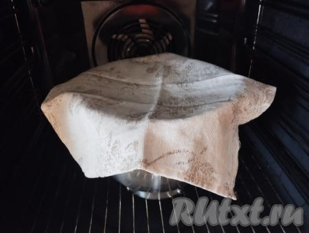 Замешанное тесто выкладываем в миску, накрываем салфеткой, ставим в тёплое место до увеличения теста в объёме в 2-3 раза (ориентировочно на 40-60 минут). Я миску с тестом для подъёма отправляю в духовку. Предварительно я разогреваю духовку в течение 3 минут и выключаю. Открываю дверцу и ставлю в духовку миску с тестом.