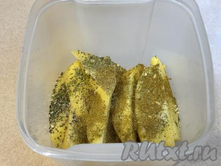 Дольки картофеля поместить в лоток с крышкой, добавить сухие специи и соль по вкусу.