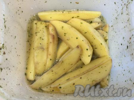 Закрыть лоток крышкой. Хорошо потрясти закрытый лоток с картофелем, чтобы дольки равномерно покрылись маслом и специями со всех сторон. Можно и просто тщательно перемешать картофель руками, равномерно покрывая его маслом и специями. Оставить картошку на минут 10.