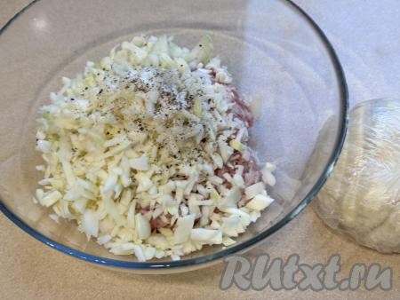 В достаточно глубокую миску выложить фарш, добавить лук и капусту, всыпать соль и чёрный молотый перец по вкусу.