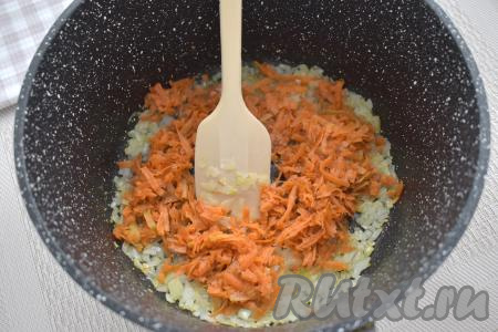К луку, обжаренному до мягкости, выкладываем натёртую на крупной тёрке морковку, перемешиваем. Обжариваем овощи минут 5 (до мягкости моркови), время от времени помешивая.
