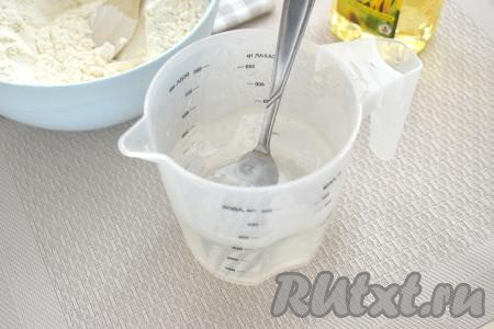 Воду наливаем в отдельную ёмкость (у меня - мерный стакан объёмом 0,5 литра), добавляем соль и растительное масло. Хорошо перемешиваем, чтобы соль растворилась.