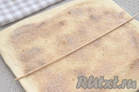 Визуально делим пласт теста на 2 равных половины. Для ориентира на середину теста я положила бамбуковую палочку.