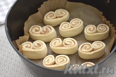 Чашу аэрогриля застилаем пергаментом, выкладываем заготовки печенья "Ушки" на расстоянии друг от друга (слоёное тесто увеличится в размере в процессе выпечки). Отправляем чашу в аэрогриль.