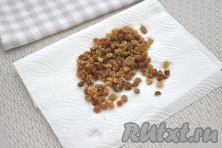 Слоёное тесто достаём из морозилки, даём ему разморозиться при комнатной температуре, чтобы оно стало достаточно мягким. Изюм перекладываем в миску, заливаем полностью кипящей водой, оставляем минут на 5, после этого откидываем на сито, промываем проточной водой, даём лишней воде стечь. Раскладываем изюм на бумажном полотенце, чтобы он обсох.