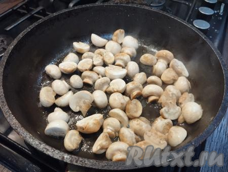 На сковороде разогреваем растительное масло, убавляем огонь до среднего, выкладываем шампиньоны. Обжариваем грибы до слегка золотистого цвета, время от времени помешивая (ориентировочно в течение 6-7 минут). Убираем с огня, даём остыть.