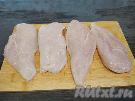 Каждое филе разрезаем вдоль на две части. В результате из 2 куриных филе у нас получатся 4 куска мяса, именно столько отбивных мы и будем готовить. Выкладываем 4 куска мяса на разделочную доску.&nbsp;