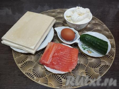 Подготовим ингредиенты для приготовления ракушек из слоёного теста с красной рыбой и творожным сыром. Красную слабосолёную рыбу можно взять любую (у меня - слабосолёная форель). Слоёное тесто (у меня - бездрожжевое) размораживаем при комнатной температуре. Огурец моем и обсушиваем.