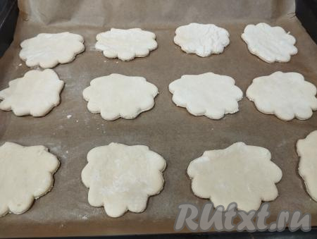 Выкладываем заготовки ракушек из слоёного теста на противень, застеленный пергаментом. Я предпочитаю использовать силиконизированный пергамент, он хорош тем, что к нему ничего не пристаёт в процессе выпечки.