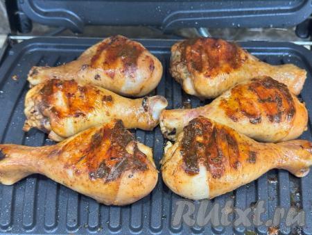 Электрогриль разогреть на режиме № 2 "Мясо", смазать панели растительным маслом. Замаринованные голени выложить на нижнюю панель электрогриля, прижать верхней панелью. Жарить примерно 35 минут. Я перевернула ножки один раз через 15 минут после начала жарки.