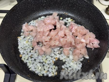 К обжаренному луку добавить мелко нарезанное куриное филе, перемешать.