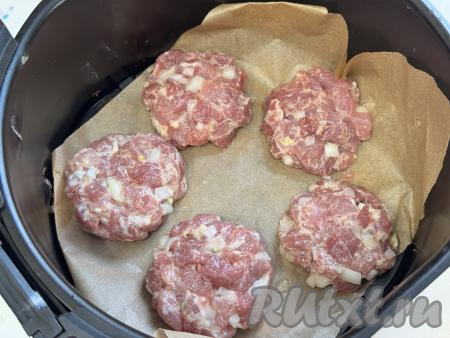 Из рубленной котлетной массы сформировать одинаковые котлеты (я сформировала 13 котлет весом примерно по 60 грамм). Дно решётки аэрогриля застелить пергаментом, если не уверены в качестве пергамента, можете его совсем немного смазать растительным маслом. Выложить часть котлет. У меня за раз в чашу аэрогриля помещается только 5 котлет, поэтому все котлеты я запекала в несколько заходов. Отправить чашу с котлетами в аэрогриль.&nbsp;