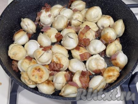 Обжарить пельмени с беконом в течение 10 минут на среднем огне, время от времени аккуратно перемешивая.