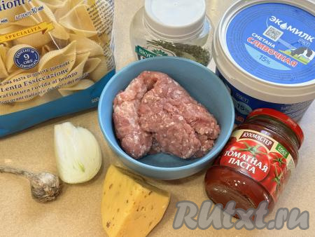 Подготовить продукты для приготовления макарон "Ракушки" с фаршем в аэрогриле. Лук и чеснок почистить. Фарш для этого блюда можно приготовить в домашних условиях, пропустив кусочки любого мяса (я взяла свинину) через мясорубку. При желании можно использовать и покупной мясной фарш. Сметану для соуса можно взять любой жирности (у меня - жирностью 15%).