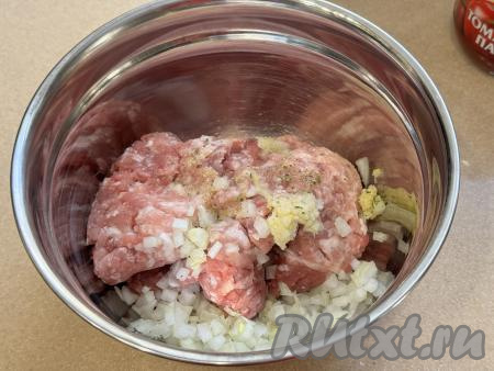 Фарш выложить в глубокую миску, добавить пропущенный через пресс чеснок и мелко нарезанный (или пропущенный через мясорубку) лук, всыпать соль и чёрный молотый перец.&nbsp;