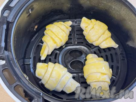 Яичный желток в небольшой ёмкости взболтать вилкой до однородности. Смазать поверхность круассанов с шоколадом взбитым желтком. Отправить чашу в аэрогриль.