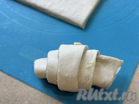 Свернуть тесто в рулетик, начиная со стороны с шоколадом, слегка растягивая тесто во время сворачивания.