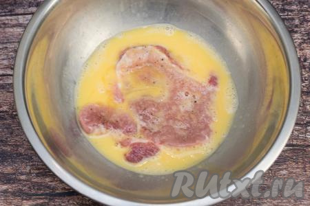 Каждую свиную отбивную окунуть с двух сторон в яичную смесь.
