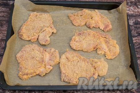 Противень застелить пергаментом (или фольгой). Смазать поверхность пергамента растительным маслом.&nbsp;Каждую отбивную, покрытую яйцом и панировочными сухарями, выкладывать на противень.