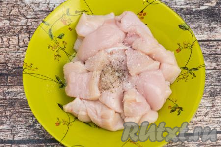 Посолить кусочки куриного филе и поперчить по вкусу.