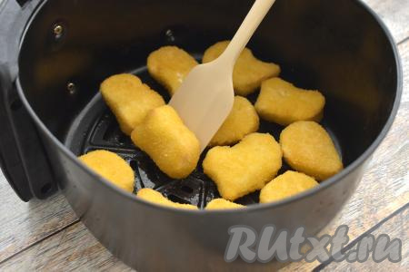 По прошествии 5 минут с начала приготовления достаём чашу из аэрогриля, наггетсы переворачиваем, отправляем в аэрогриль и запекаем оставшиеся 5 минут. Если наггетсы крупные, увеличьте время приготовления в аэрогриле на 2-3 минуты.