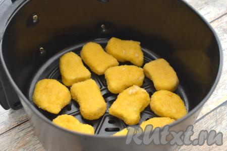 Наггетсы, смазанные маслом, выкладываем в чашу аэрогриля на решётку. Раскладывать наггетсы нужно в один слой, оставляя между ними пространство, чтобы лучше циркулировал воздух в процессе приготовления. Отправляем чашу в аэрогриль. Включаем аэрогриль на 200 градусов, а время выставляем - 10 минут.