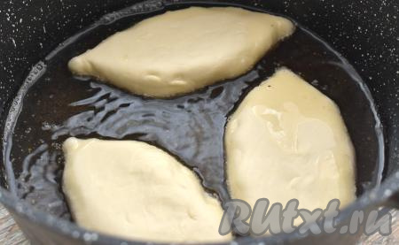 В сковороде разогреваем столько масла, чтобы оно доходило до середины пирожков. В раскалившееся масло выкладываем несколько сформированных пирожков из слоёного теста швом вниз. Жарим пирожки с картошкой на среднем огне до подрумянивания с двух сторон (примерно по 2,5-3 минуты с каждой стороны).