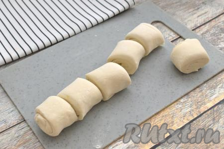 Слоёное тесто у меня было в двух пластах. Вначале первый размороженный пласт слоёного теста выкладываем на рабочую поверхность слегка припылённую мукой. Не раскатывая, пласт слоёного теста, начиная с более широкой стороны, сворачиваем в плотный рулет. Получившийся рулет разрезаем на 6 равных частей.