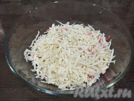 В эту же миску выкладываем сыр, натёртый на крупной тёрке.