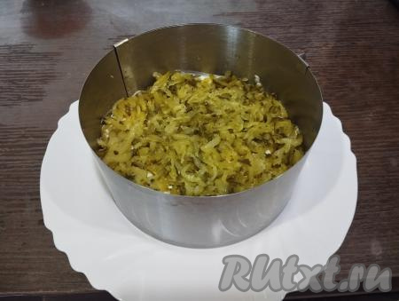 Вторым слоем выкладываем солёные огурцы, натёртые на крупной тёрке.