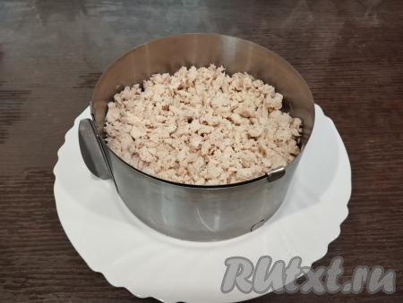 Следующим слоем выкладываем мелко нарезанное куриное филе, немного утрамбовываем вилкой.