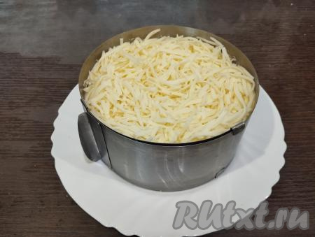 Последним слоем выкладываем сыр, натёртый на крупной тёрке.