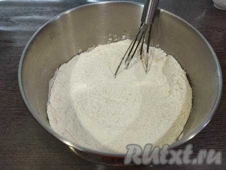 Начинаем постепенно всыпать просеянную муку, вначале перемешивая тесто венчиком.