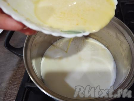 Когда молоко в кастрюле хорошо прогреется, но не закипит, вливаем в него тонкой струйкой, постоянно перемешивая венчиком, желтковую массу.