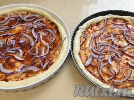 На тесто выложить полукольца лука.&nbsp;