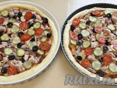 Маслины, если будете использовать, нарезать на тонкие кружочки. Помидоры вымыть, нарезать на кружочки. Маслины и помидоры равномерно распределить по двум заготовкам пиццы.