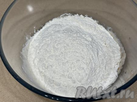 Частями начать добавлять муку, вначале перемешивая дрожжевое тесто для пиццы столовой ложкой. После того как тесто станет сложно перемешивать ложкой, подсыпая по мере необходимости муку, продолжить замешивать его руками.&nbsp;