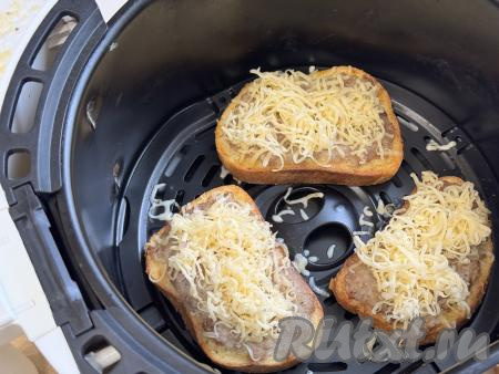 Затем достать чашу с бутербродами из аэрогриля, присыпать сверху частью натёртого сыра, отправить в аэрогриль, запекать ещё 3 минуты.&nbsp;