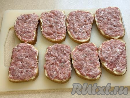 Затем зрительно разделить фарш на 8 равных частей (по количеству кусков батона). Смазать каждый кусок батона частью фарша.&nbsp;