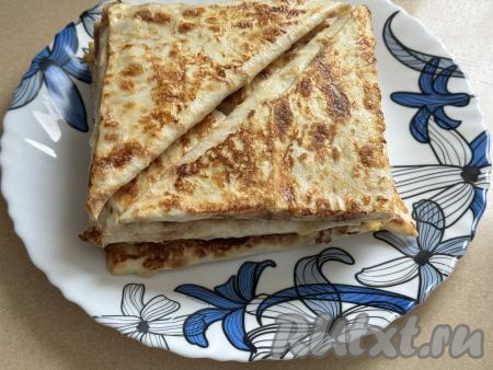 Готовые треугольника из лаваша перекладывать со сковороды на плоское блюдо. Постепенно пожарить все заготовки из лаваша с начинкой из крабовых палочек, не забывая&nbsp;предварительно покрывать их с двух сторон яйцом.