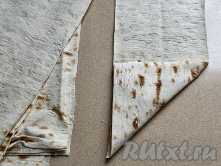 Завернуть чистый край лаваша на начинку в виде треугольника. Далее сворачивать лаваш треугольником, пока лаваш не закончится. Свободный конец завернуть внутрь лаваша.