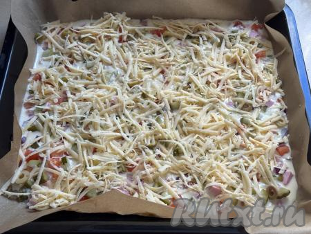 Сверху присыпать пиццу сыром, натёртым на крупной тёрке.