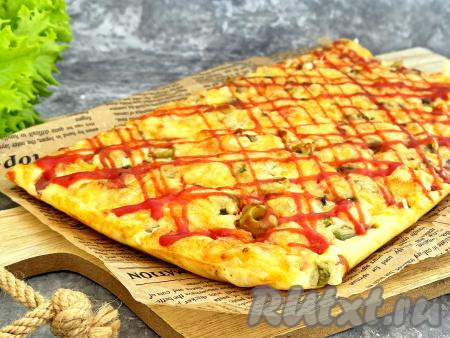 Готовую пиццу снять с противня и отделить от пергамента.