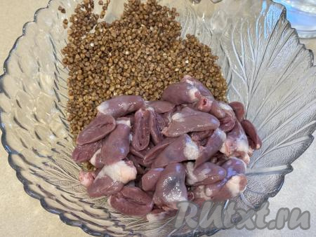 Куриные сердечки разрезать пополам, промыть водой, убирая сгустки крови. В глубокой миске соединить сердечки и гречку.&nbsp;