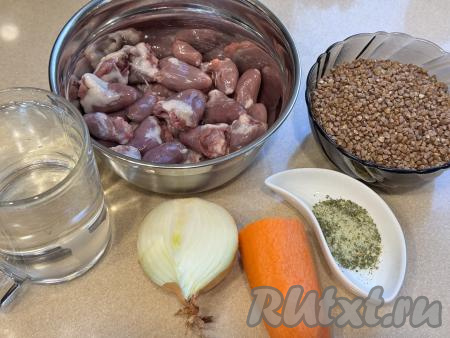 Подготовить продукты для приготовления куриных сердечек с гречкой в духовке. Лук и морковь почистить. Гречку, если необходимо, перебрать. Выложить гречку в сито, тщательно промыть её под проточной водой.&nbsp;